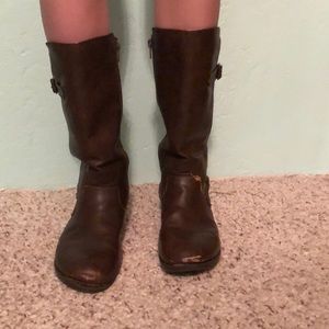 Brown mid length boots that are slightly worn